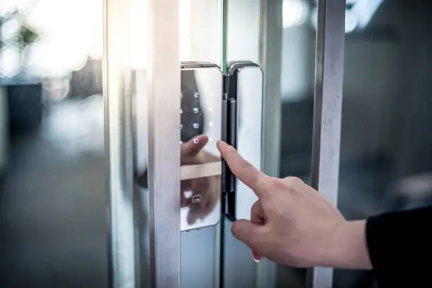 istockphoto-1187658587-612x612 Businessman hand pressing down password number on electronic access control machine to open the office door. Security system concept